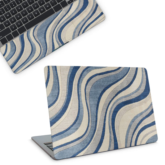 Laptop with a blue and beige wavy patterned skin on a white background