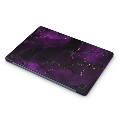 macbook skin with purple ink design on bottom