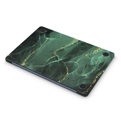 macbook skin with green ink design on bottom